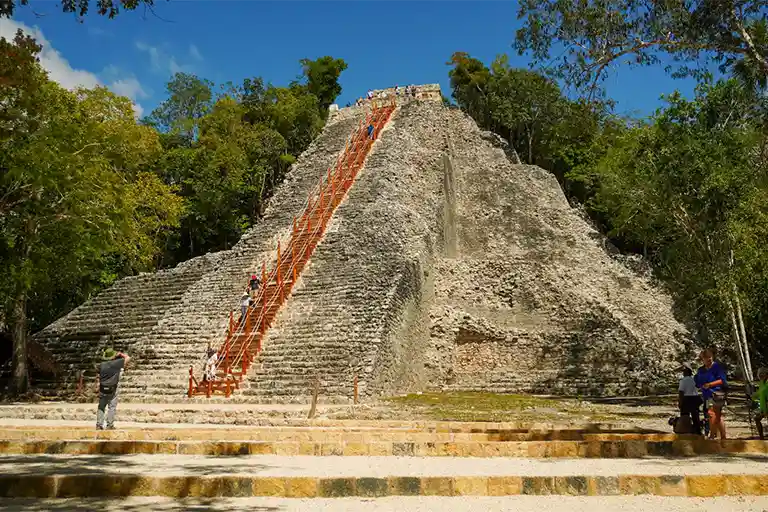 The Nohoch Mul stone pyramid in Cobá with its wide staircase beneath a clear blue sky