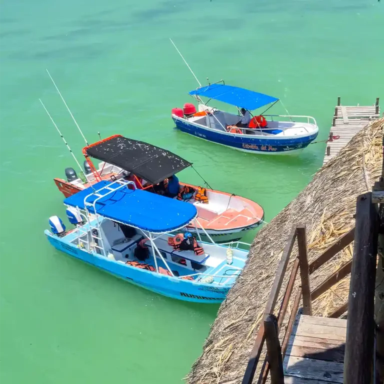 Boat tour off Isla Holbox with small excursion boats in crystal-clear water